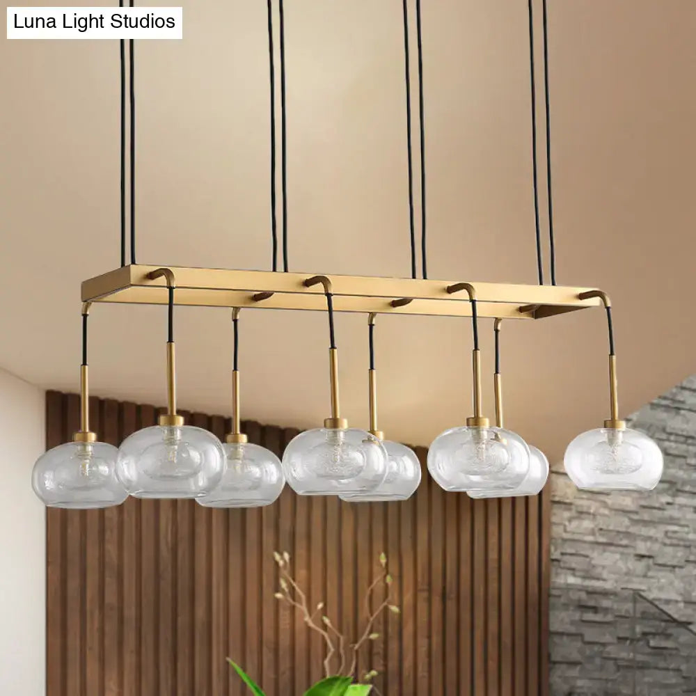 DecorBites post-modern island chandelier with clear glass globe pendants and brass rectangular frame suspended by black cords