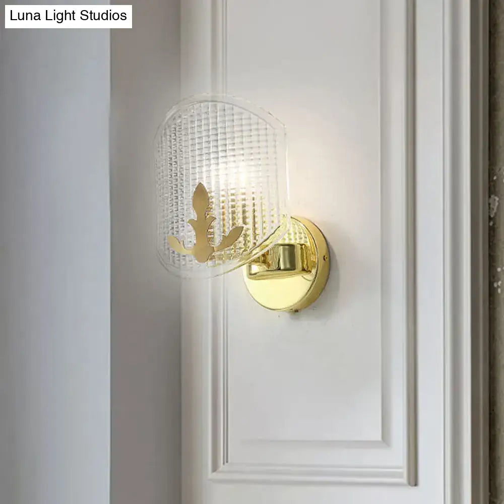 Post-modern gold wall sconce with clear lattice glass shade and elegant leaf cutout for bedroom lighting