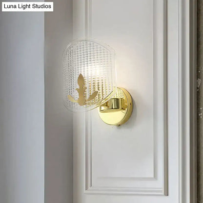 Post-modern gold wall sconce with clear lattice glass shade and elegant leaf cutout for bedroom lighting