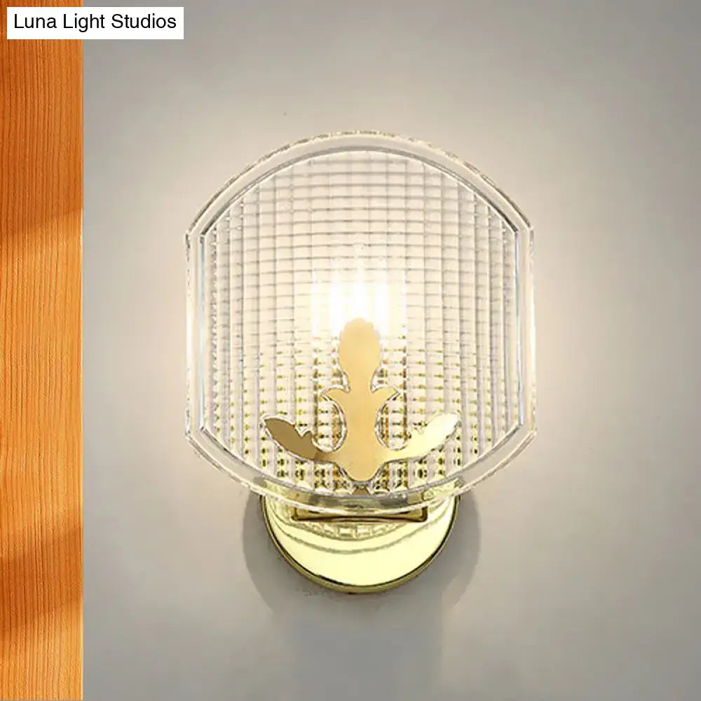 Post-modern gold wall sconce featuring a clear lattice glass with textured grid and gold-toned anchor design