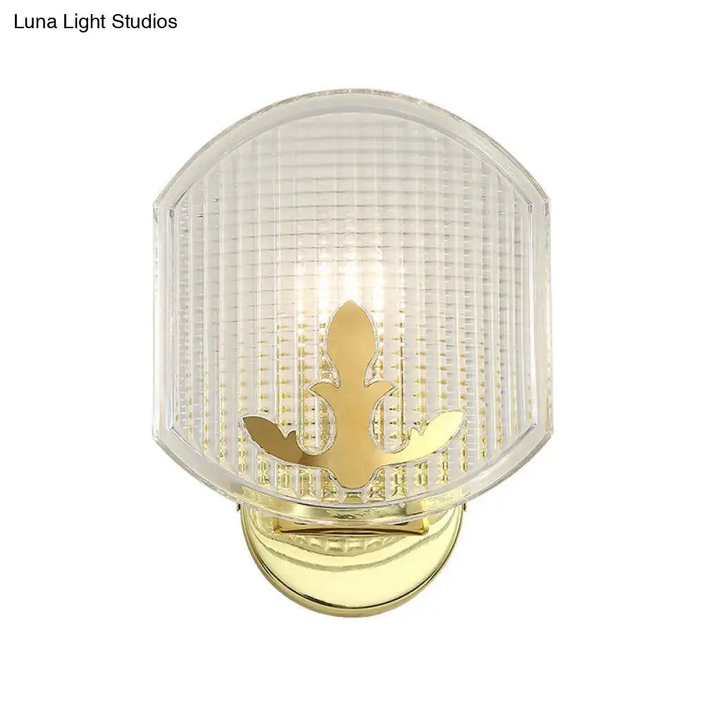 Post-modern gold wall sconce with clear lattice glass shade and ornate fleur-de-lis design for bedroom lighting