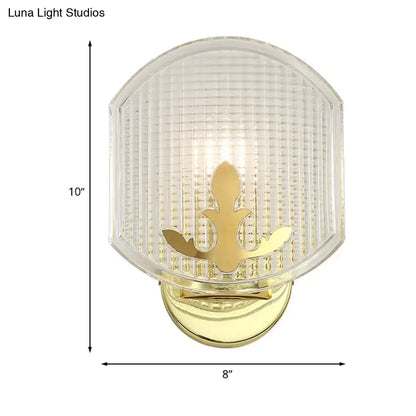 Post-modern gold wall sconce with clear lattice glass shade featuring ornate leaf motif for bedroom lighting