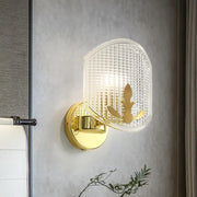 Post-modern gold wall sconce with clear lattice glass shade and ornate gold leaf design for bedroom lighting