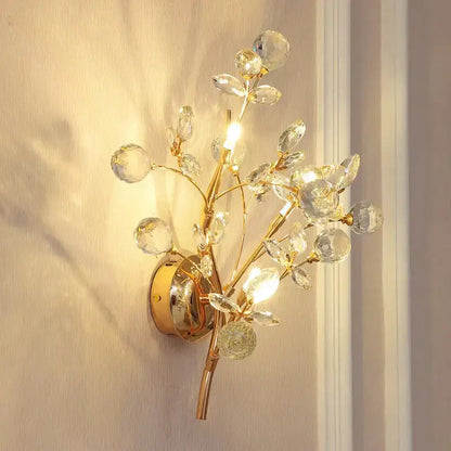 Post modern luxury gold crystal branch wall sconce with faceted clear crystals and polished brass base for bedroom use