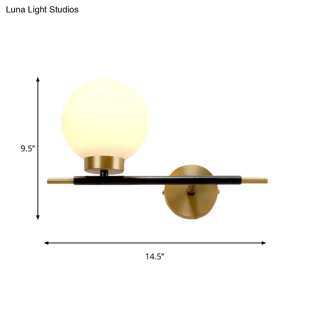 Post-modern white and brass sphere wall sconce with frosted glass globe and black metal arm for bedroom lighting