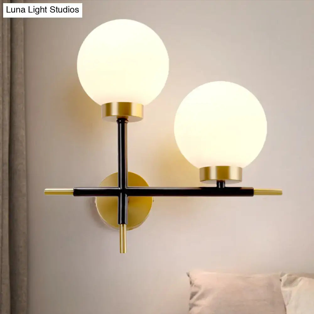 Post-modern sphere wall sconce with frosted glass globe shades and sleek black-and-gold metal frame for bedroom lighting