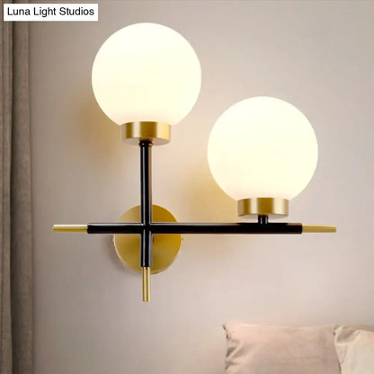 Post-modern sphere wall sconce with frosted glass globe shades and sleek black-and-gold metal frame for bedroom lighting