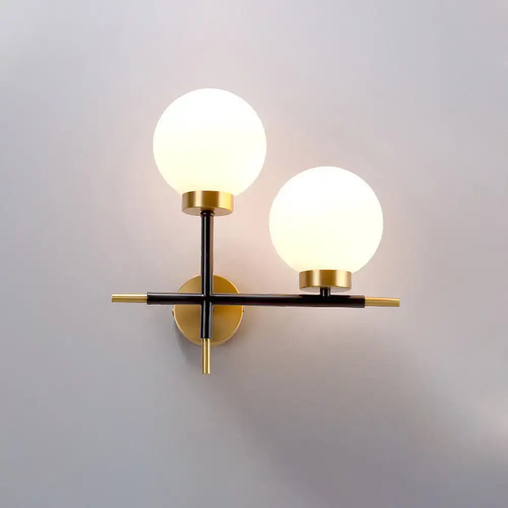 Modern sphere wall sconce with frosted glass globes and brass black frame for bedroom lighting