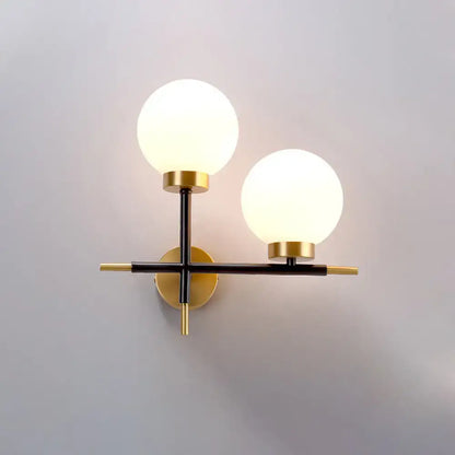 Modern sphere wall sconce with frosted glass globes and brass black frame for bedroom lighting