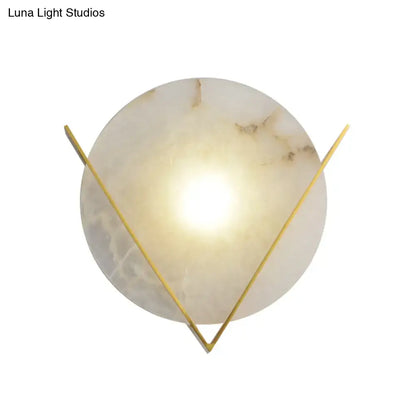 Post modern round panel wall light sconce in white marble with brown veining and gold-toned triangular frame for bedroom