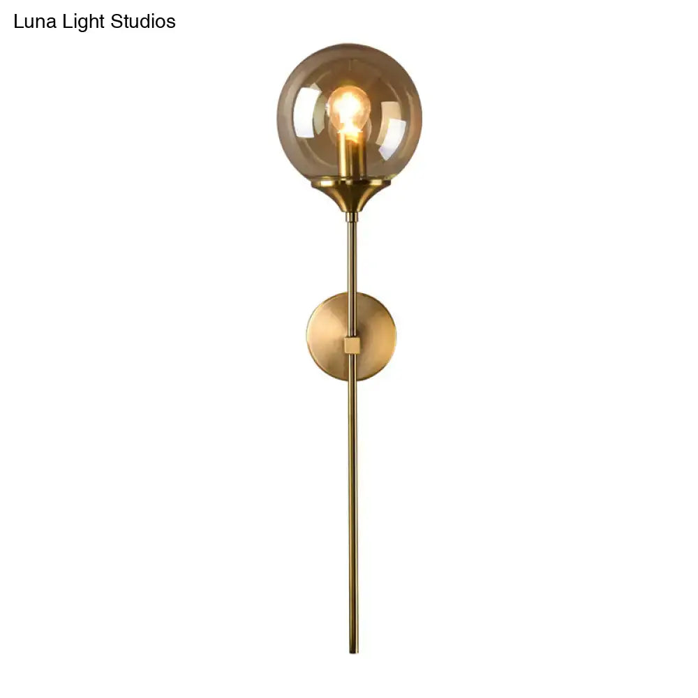 Brass-finished wall sconce with smoke grey glass globe and exposed filament e27 bulb for bedroom lighting