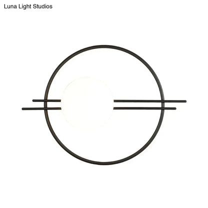 Black brass sconce light featuring a postmodern circular design with white glass and horizontal bars for bedroom use