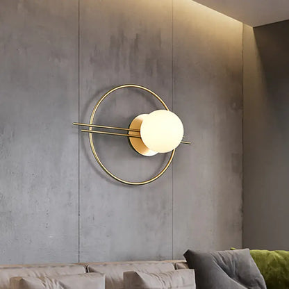 Postmodern black brass sconce light with gold-toned circular frame and white glass globe for bedroom lighting