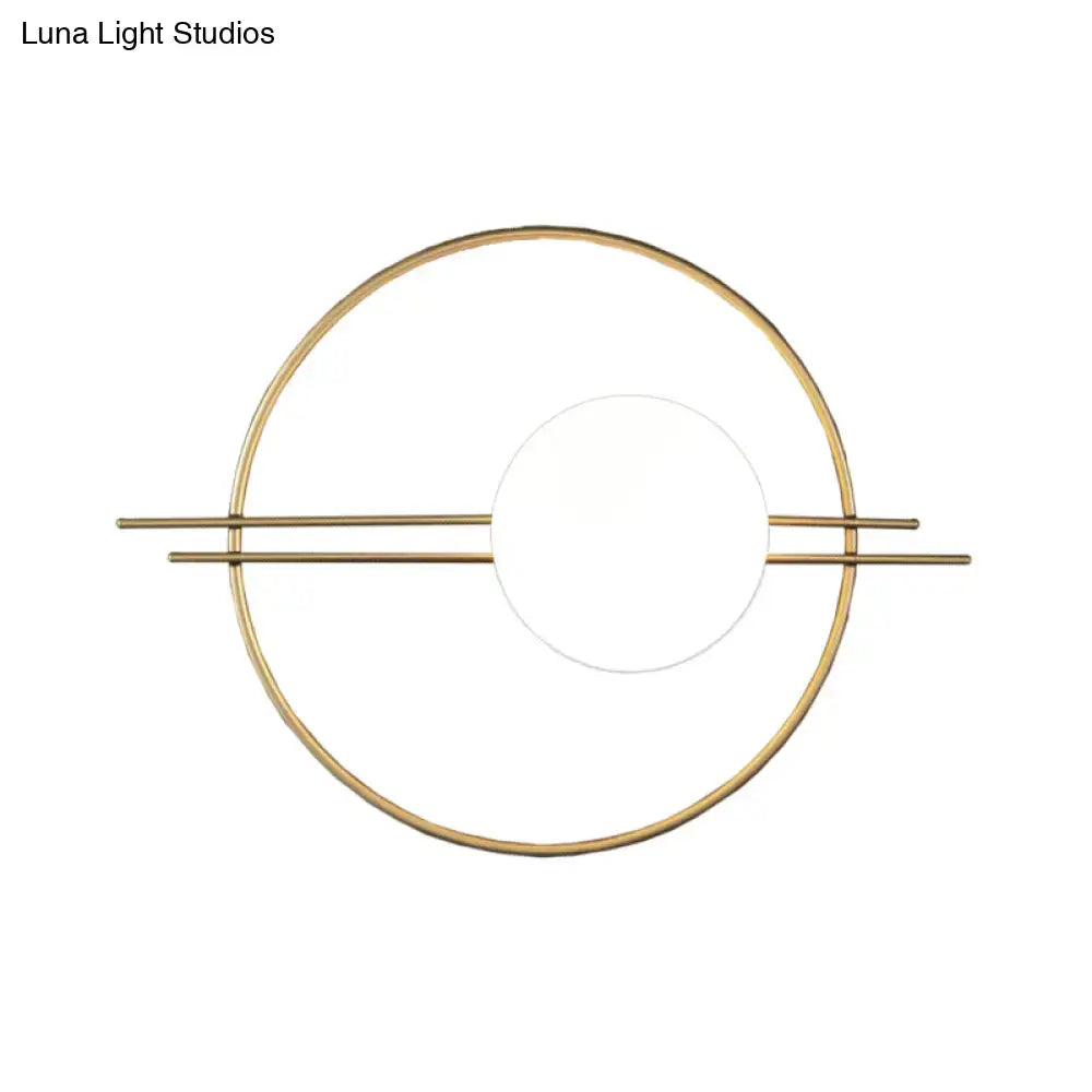Gold-toned minimalist postmodern sconce light with black brass frame and white glass for bedroom use
