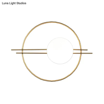 Gold-toned minimalist postmodern sconce light with black brass frame and white glass for bedroom use