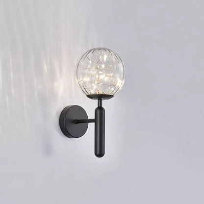 Postmodern black metal wall sconce with a prismatic glass shade and warm LED fairy lights in modern style