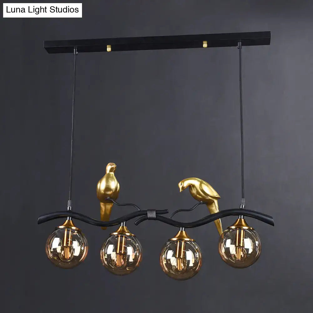 Black metal pendant light with gold bird sculptures and amber ball glass shades by DecorBites postmodern design