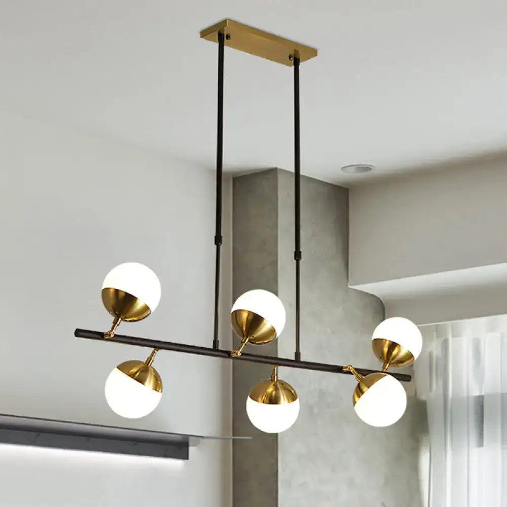 Postmodern black and gold island ceiling light with five white glass shades on polished brass fixtures for kitchen island