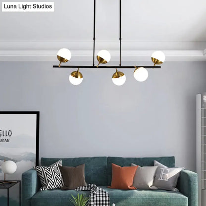 Modern black metal island ceiling light with five white glass globes and gold-toned fixtures for kitchen pendant lighting