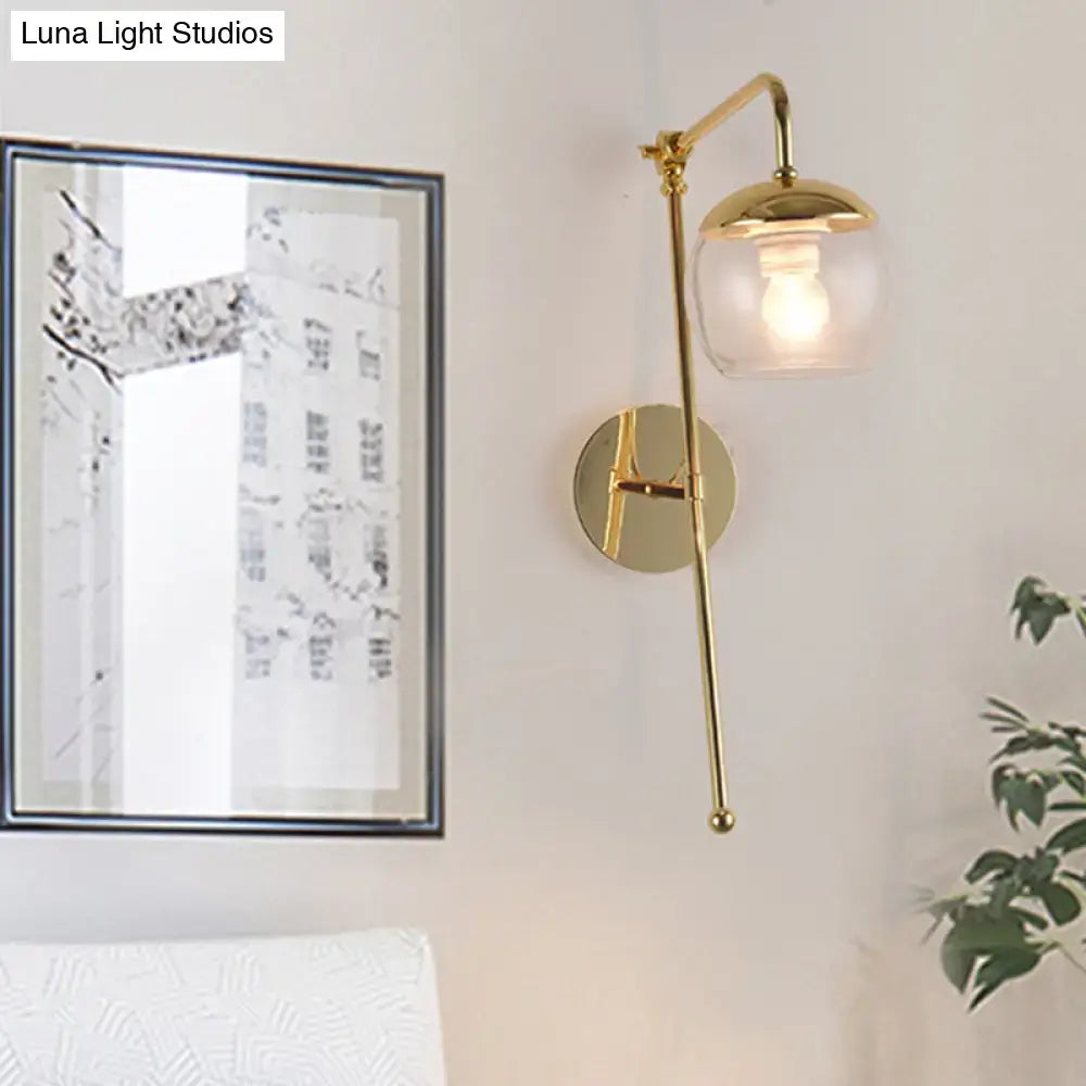 Postmodern black and gold swing arm wall sconce with clear glass globe and adjustable arm for bedroom lighting