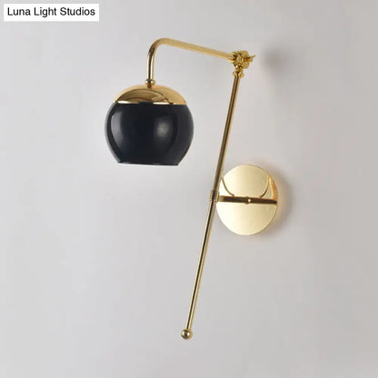 A sleek black and gold postmodern swing arm wall sconce with clear glass and polished brass bedroom light fixture