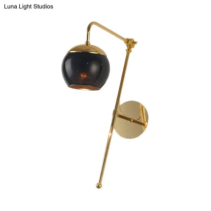 Postmodern gold finish swing arm wall sconce with glossy black spherical glass shade and clear glass elements for bedroom lighting