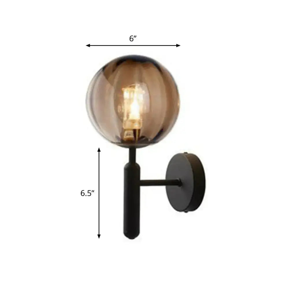 A sleek postmodern gold black wall sconce with amber glass globe and exposed bulb for 110v-120v use