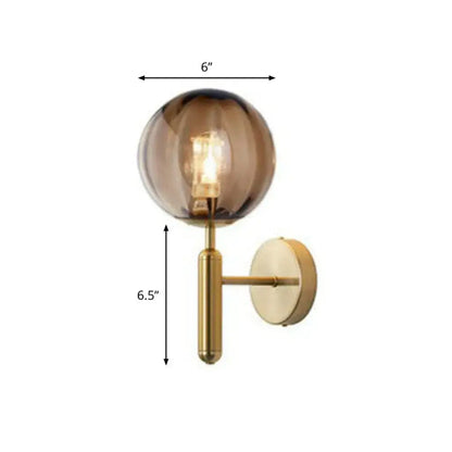 A postmodern gold black wall sconce with a spherical amber glass globe and minimalist stem 110v-120v for bedroom use