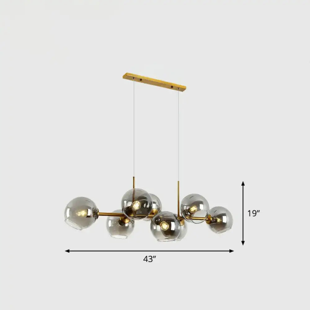 Modern brass chandelier with clear smoke grey glass globe shades designed for dining room lighting