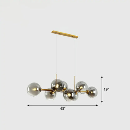 Modern brass chandelier with clear smoke grey glass globe shades designed for dining room lighting