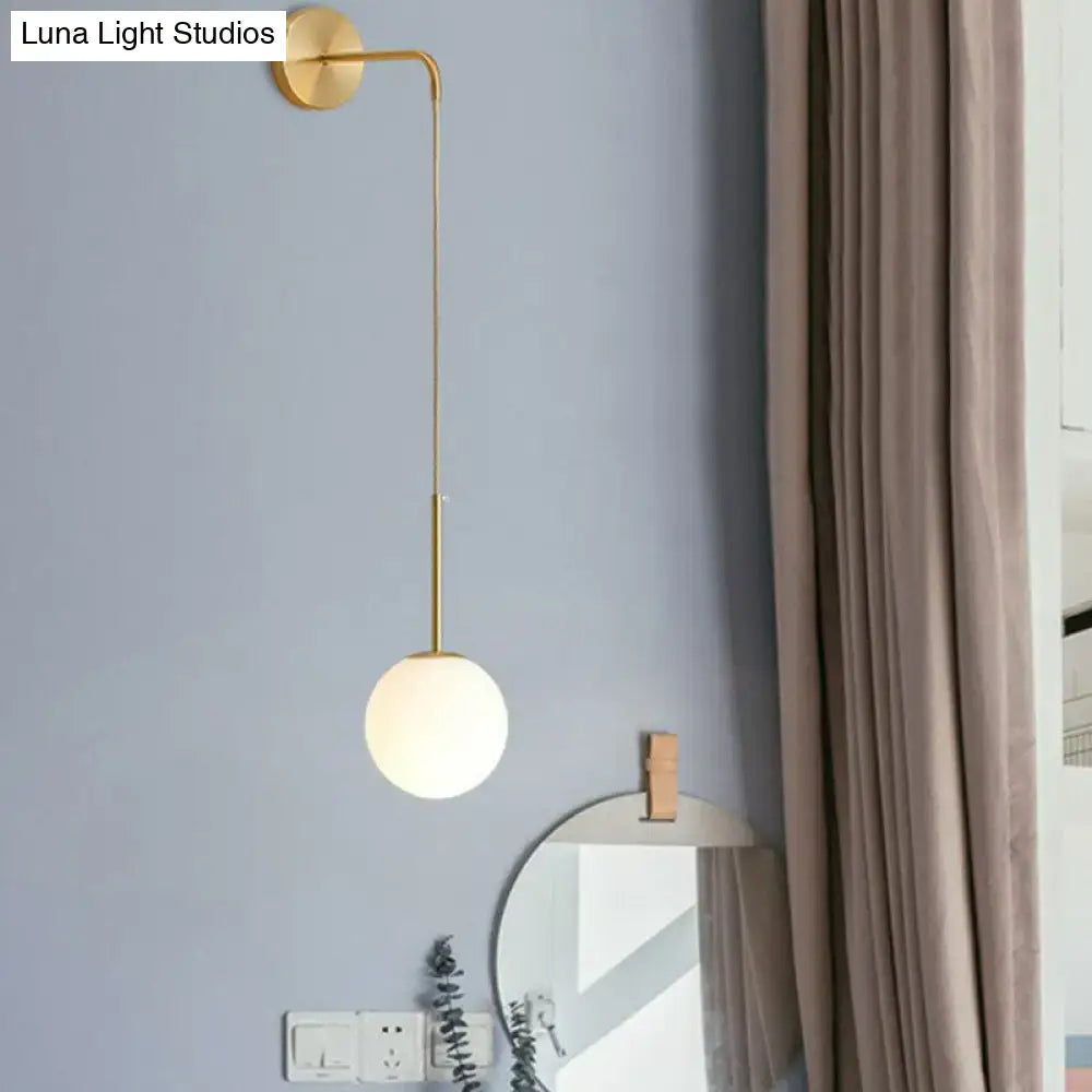 Postmodern black wall lamp with gold finish and spherical frosted glass globe for bedroom lighting