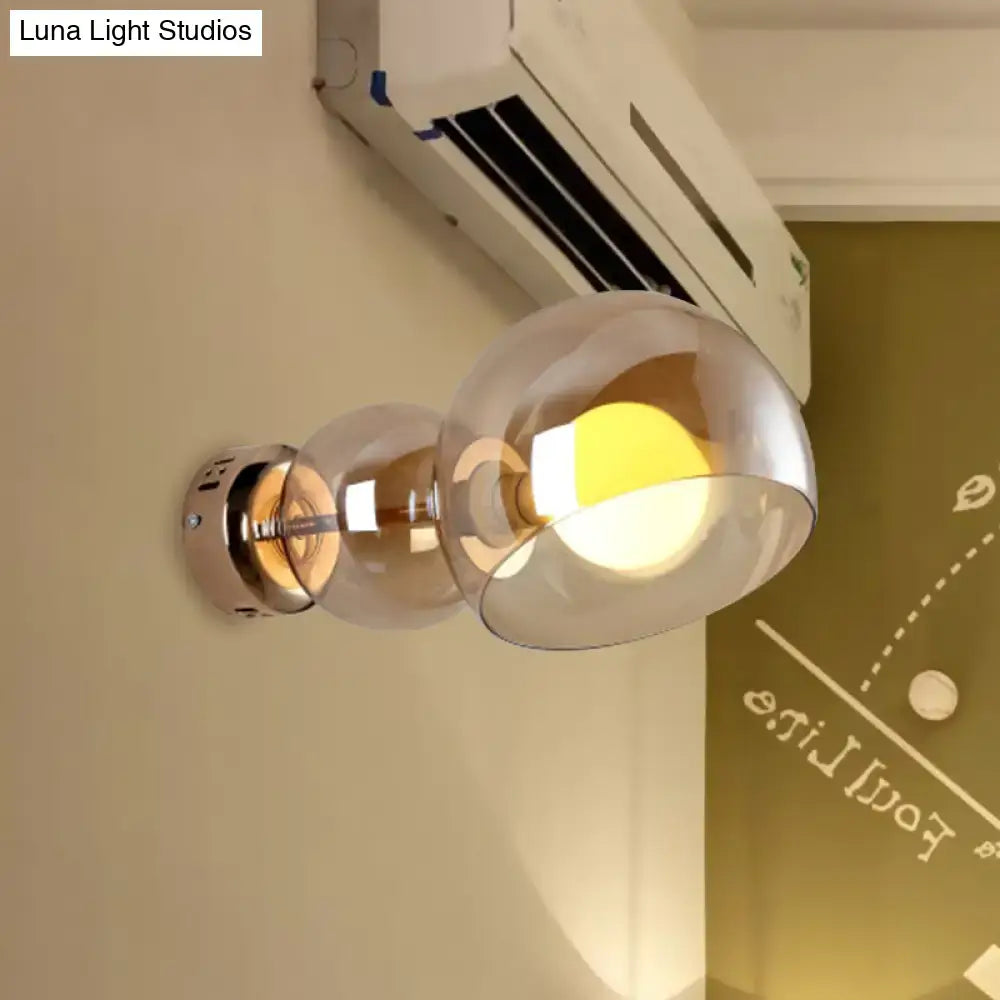 Modern wall lamp with three interconnected amber glass spheres and polished chrome finish for bedroom sconce lighting