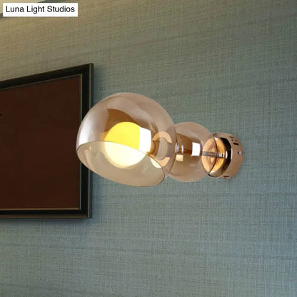Modern wall lamp with two amber glass shade globes and brushed brass finish for bedroom sconce lighting