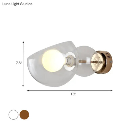 Postmodern brass amber glass wall lamp with frosted amber glass shade and exposed bulb in curved design for bedroom
