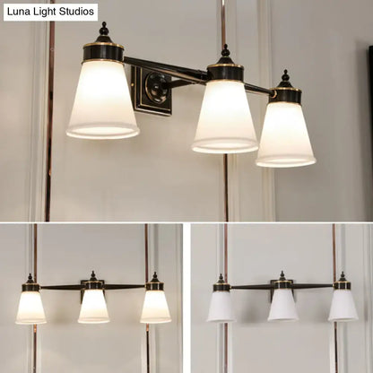 Elegant black and brass three-light wall sconce with frosted cream glass shades for bathroom vanity lighting