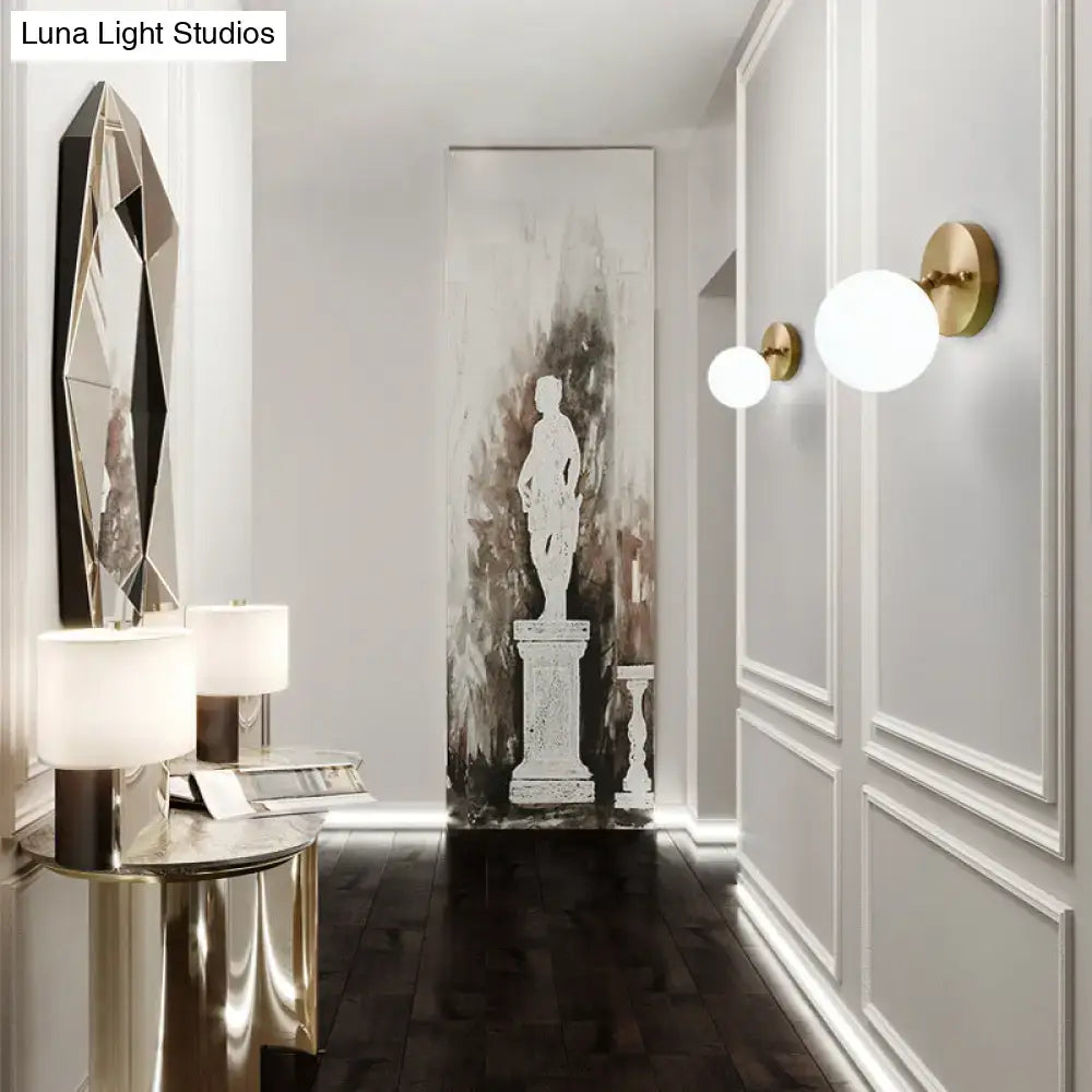 Postmodern gold-toned brass and glass wall sconce with frosted spherical shades light type bulb included