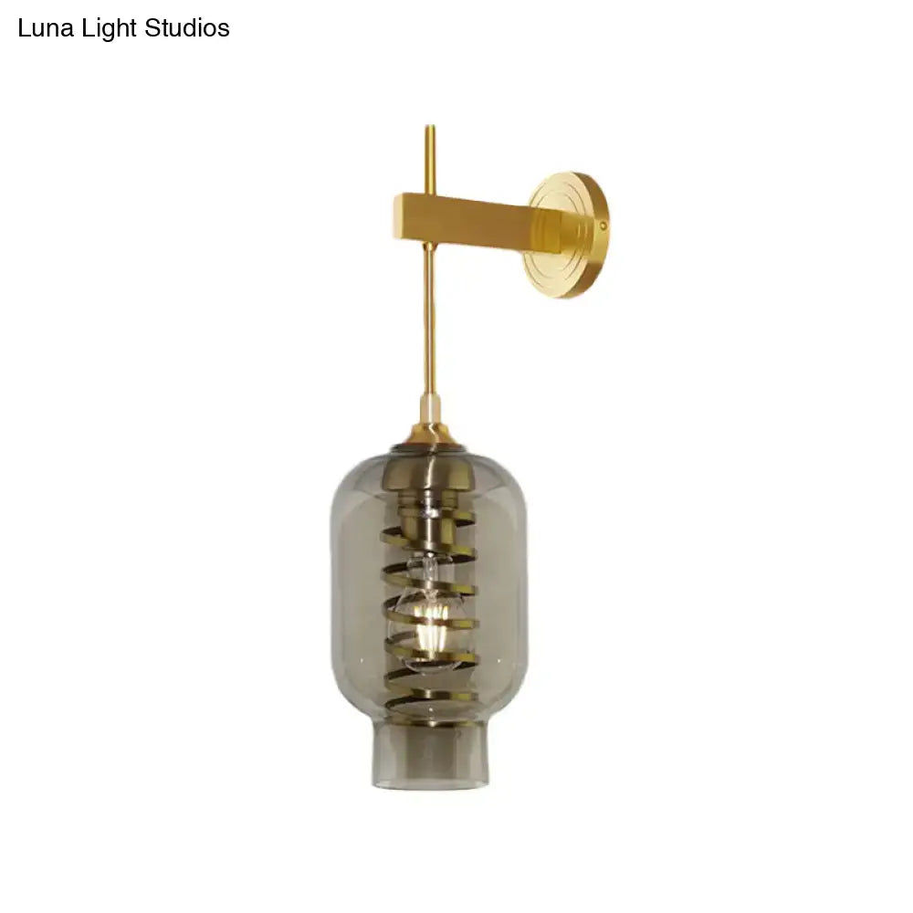 Postmodern brass wall lamp with smoke gray glass shade and intricate spiral design for tea room lighting