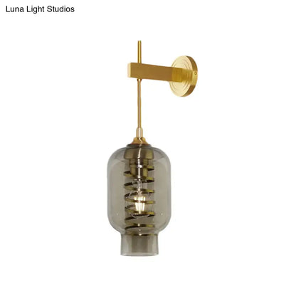 Postmodern brass wall lamp with smoke gray glass shade and intricate spiral design for tea room lighting