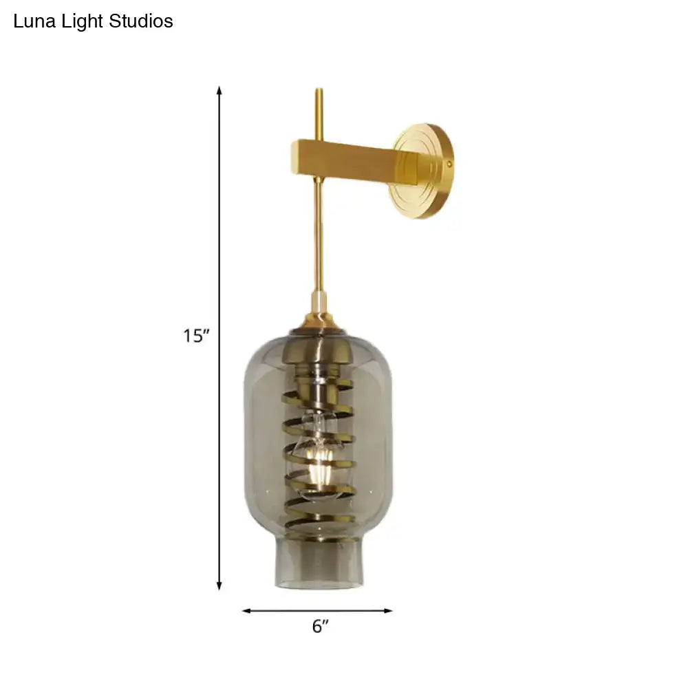 A modern postmodern wall lamp with brass arm and amber smoke gray glass shade for tea room lighting