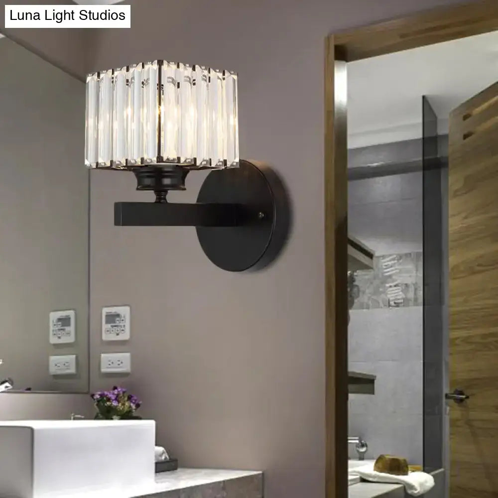 Postmodern brass black crystal block wall sconce with cylindrical crystal shade mounted on black wall for bedroom