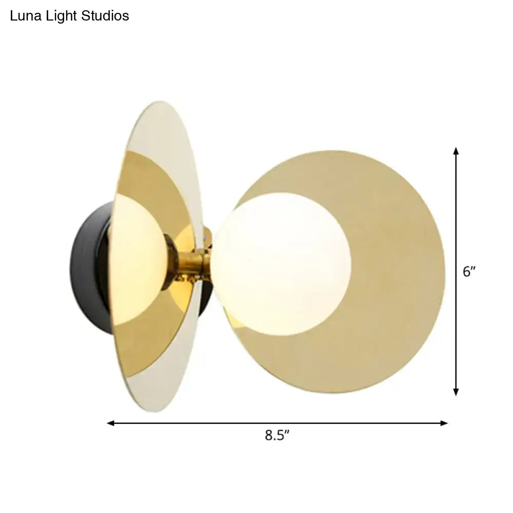 Modern wall sconce with overlapping gold-toned circular shades and mini milk glass bulb on black base for 220v-240v use