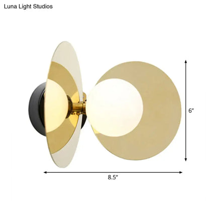 Modern wall sconce with overlapping gold-toned circular shades and mini milk glass bulb on black base for 220v-240v use