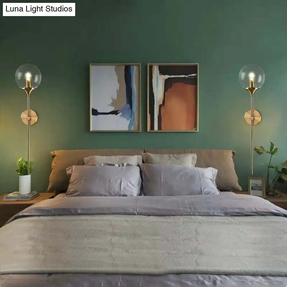 Postmodern brass pencil arm wall lamp with gold-toned spherical glass globes for bedroom sconce lighting