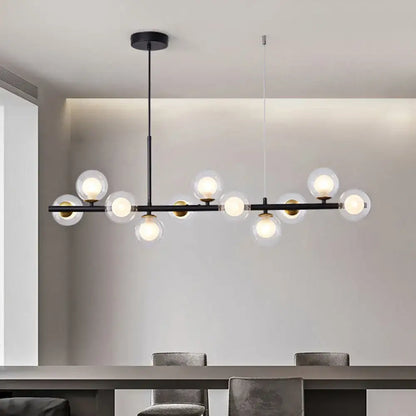 Modern black metal pendant light with clear glass globe bulbs and gold-toned accents for kitchen lighting