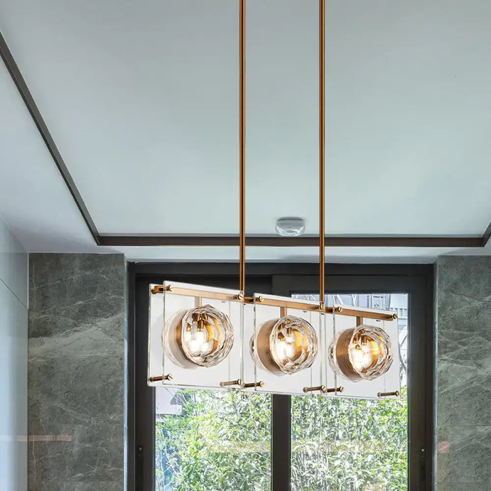 Postmodern gold and clear glass 3-light kitchen island light with brass frame and three spherical bulbs for island lighting