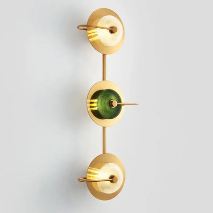 Postmodern gold wall sconce with three glass disc shades in clear and olive mounted lamp with brass rods for living room