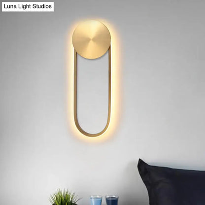 Modern gold-toned direct wired electric wall lamp with sleek oval design and softly glowing led light for bedroom use