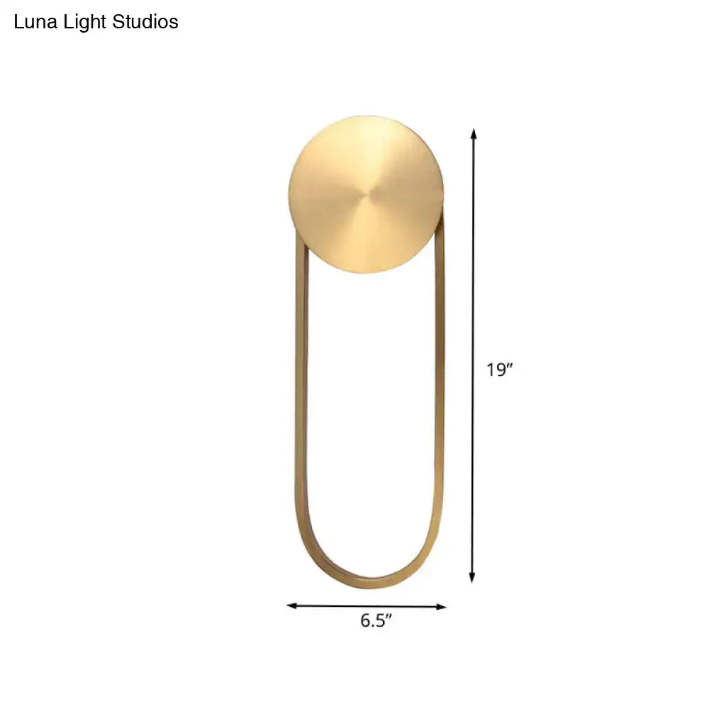 A sleek postmodern gold arc direct wired wall lamp with brushed brass finish and oval frame for bedroom lighting