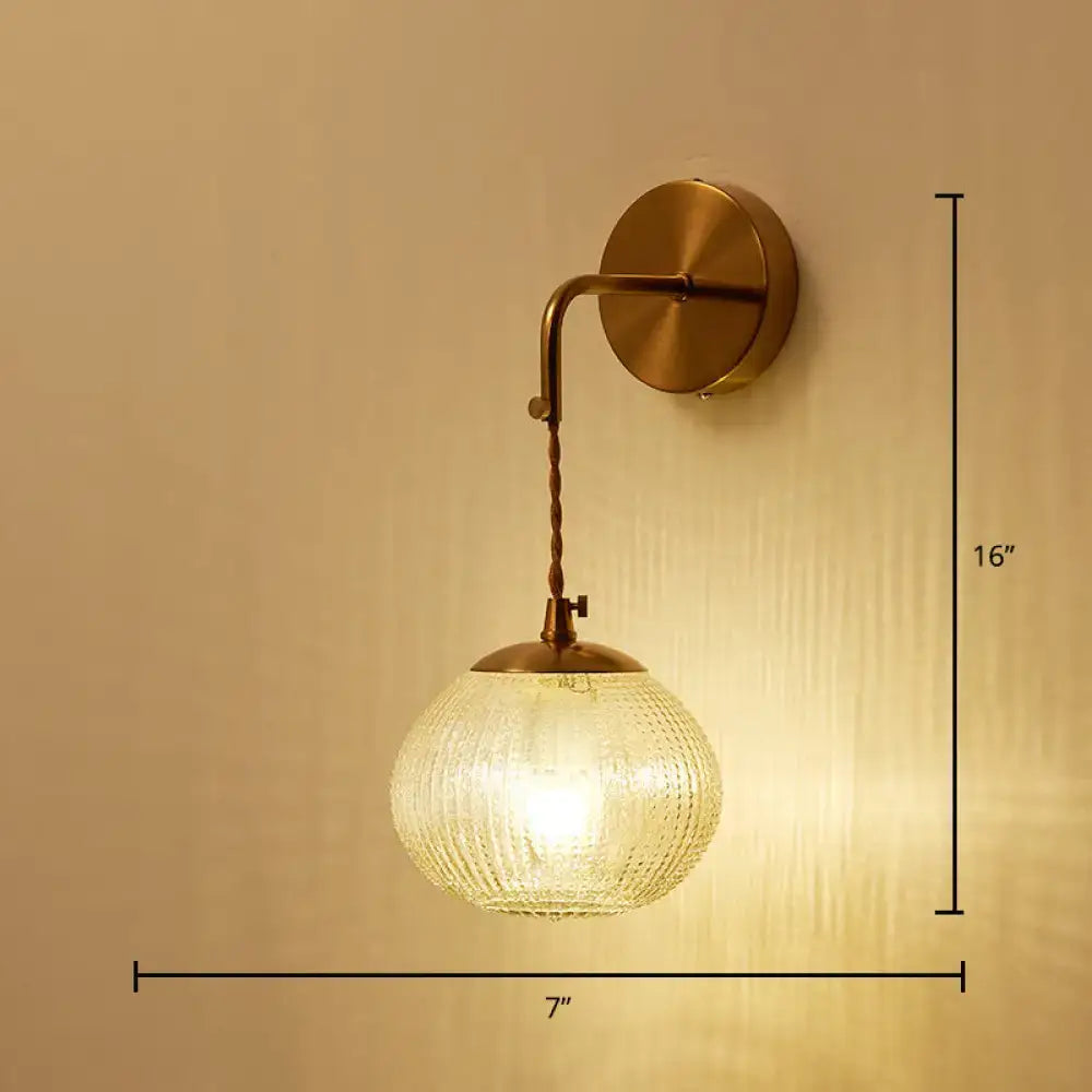 Postmodern gold ball shaped wall sconce with warm brass finish and textured glass shade for bedroom lighting