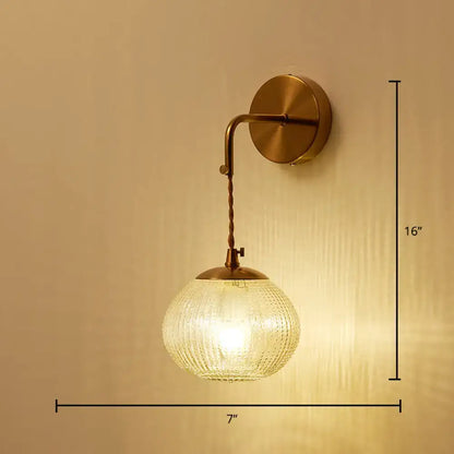Postmodern gold ball shaped wall sconce with warm brass finish and textured glass shade for bedroom lighting